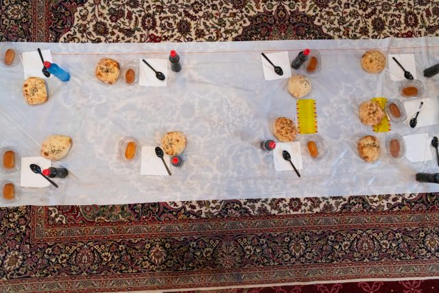 Top view of people serving food at a Mosque a communal meal during Ramadan before breaking the fast on Iftar dinner (1 of 28)