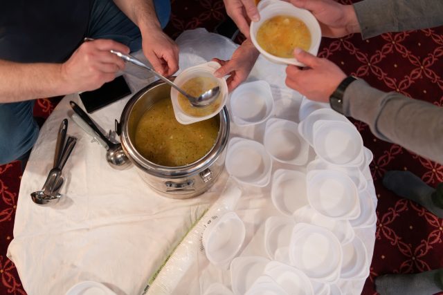 Top view of people serving food at a Mosque a communal meal during Ramadan before breaking the fast on Iftar dinner (7 of 28)