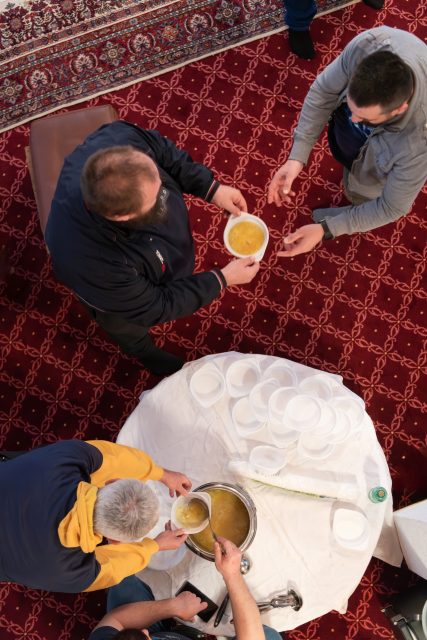 Top view of people serving food at a Mosque a communal meal during Ramadan before breaking the fast on Iftar dinner (13 of 28)