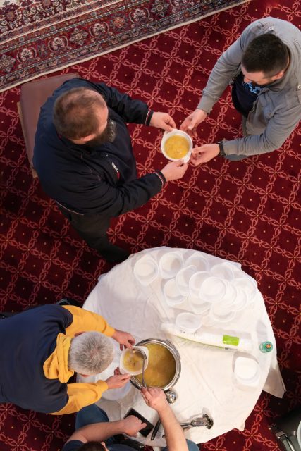 Top view of people serving food at a Mosque a communal meal during Ramadan before breaking the fast on Iftar dinner (14 of 28)