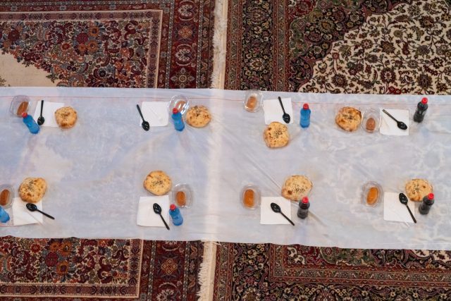 Top view of people serving food at a Mosque a communal meal during Ramadan before breaking the fast on Iftar dinner (3 of 28)