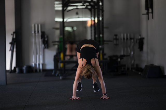 A woman performs a handstand in a modern gym setting
