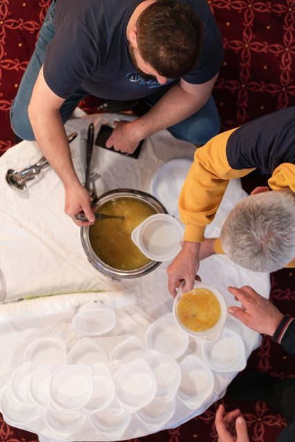Top view of people serving food at a Mosque a communal meal during Ramadan before breaking the fast on Iftar dinner (10 of 28)
