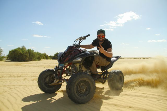 mp70353375-young-quad-bike-rider-doing-wheelie-in-desert.jpg