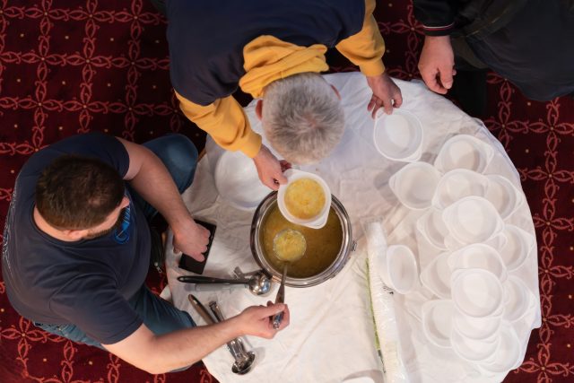 Top view of people serving food at a Mosque a communal meal during Ramadan before breaking the fast on Iftar dinner (12 of 28)