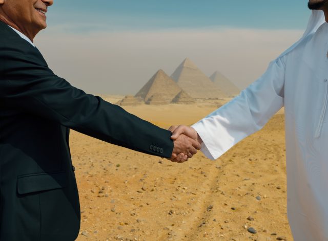 mp71514789-western-businessman-in-suit-and-gulf-arab-man-in-white.jpg