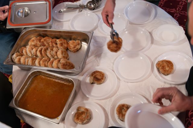 Top view of people serving food at a Mosque a communal meal during Ramadan before breaking the fast on Iftar dinner (17 of 28)