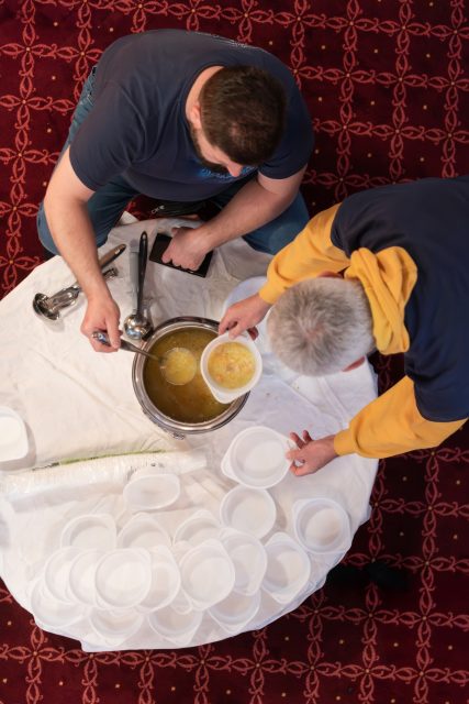 Top view of people serving food at a Mosque a communal meal during Ramadan before breaking the fast on Iftar dinner (9 of 28)