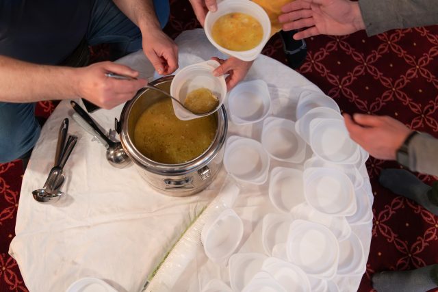 Top view of people serving food at a Mosque a communal meal during Ramadan before breaking the fast on Iftar dinner (6 of 28)